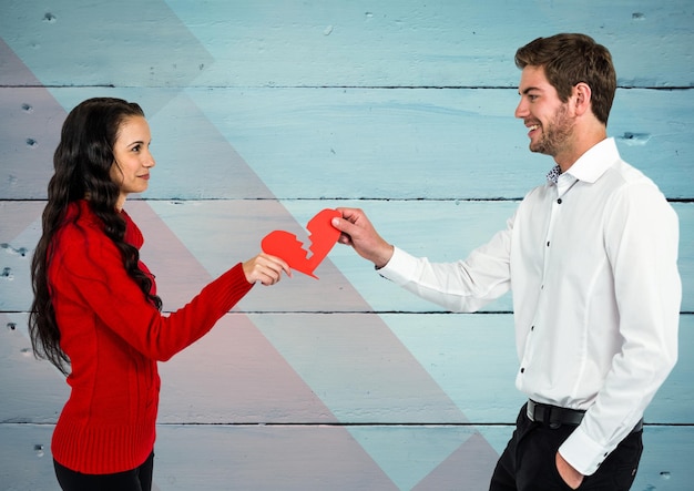 Foto pareja sosteniendo un corazón roto