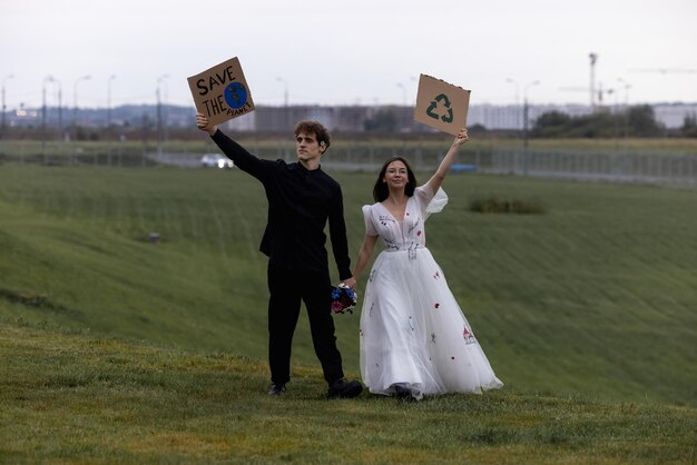 Foto una pareja sostiene carteles que dicen salvar la tierra y reciclar