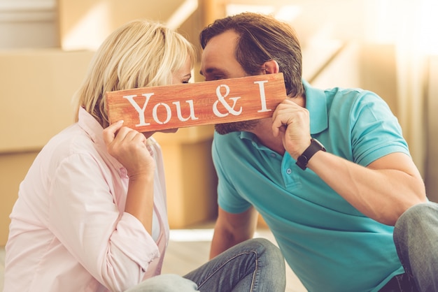 Pareja sostiene una placa de madera con inscripción.