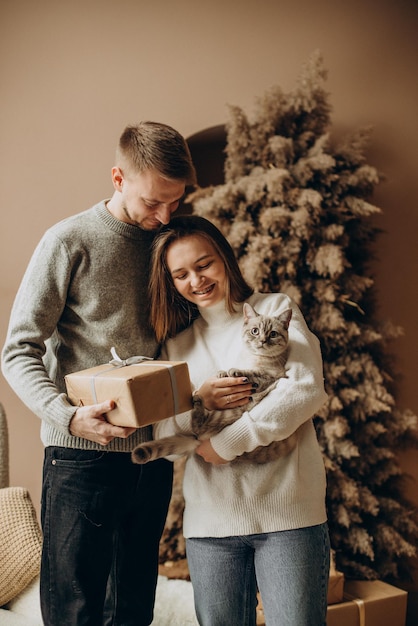 Pareja con su gatito celebrando la Navidad