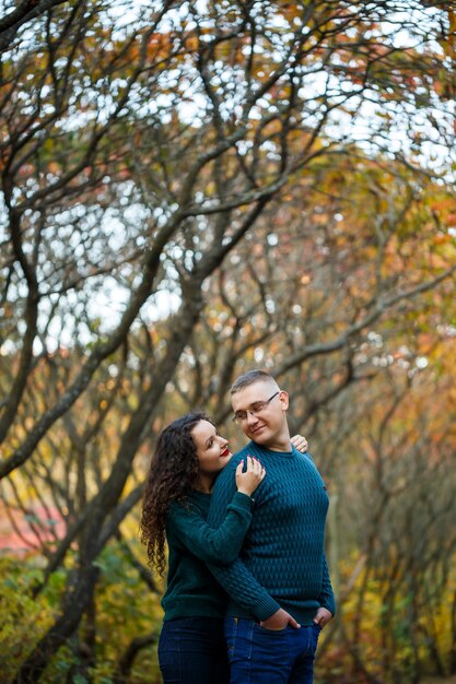 Pareja de suéteres en el parque otoño