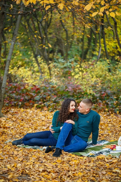 Pareja de suéteres en el parque otoño