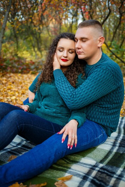 Pareja de suéteres en el parque otoño