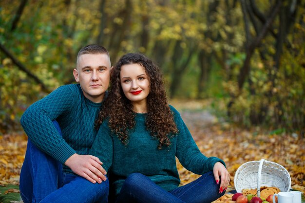 Pareja de suéteres en el parque otoño