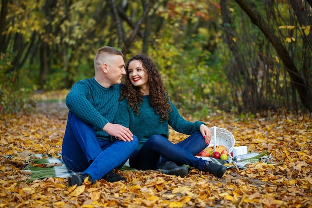 Pareja de suéteres en el parque otoño