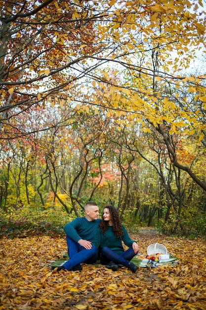 Pareja de suéteres en el parque otoño