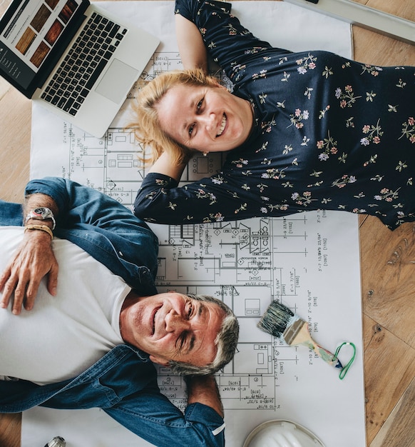 Foto pareja tendida en el suelo de madera en su nueva casa