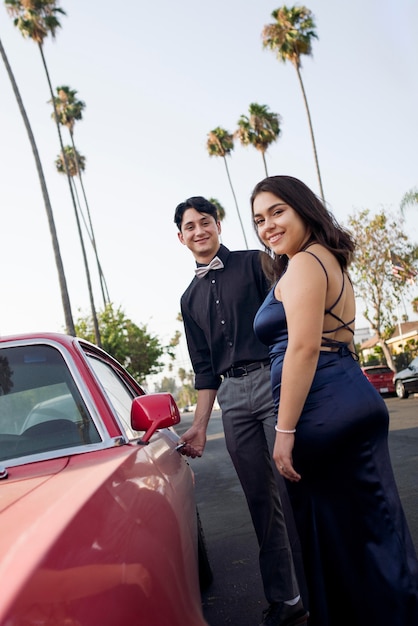 Foto pareja de tiro medio yendo al baile de graduación con coche