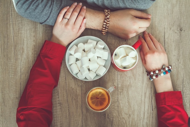 Pareja tomados de la mano y bebiendo té