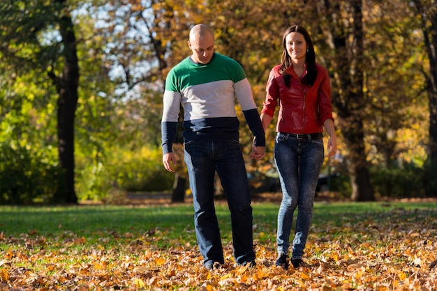 pareja tomados de la mano y caminando en el bosque durante