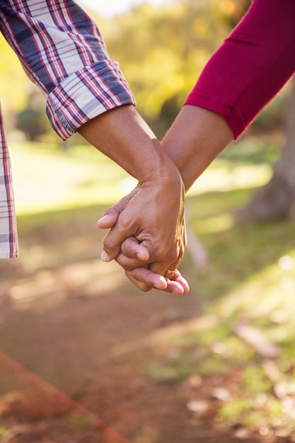 Pareja tomados de la mano en el parque