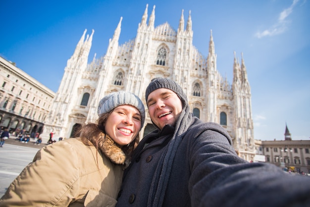 Pareja tomando autorretrato en la plaza del Duomo de Milán. Concepto de viaje y relación