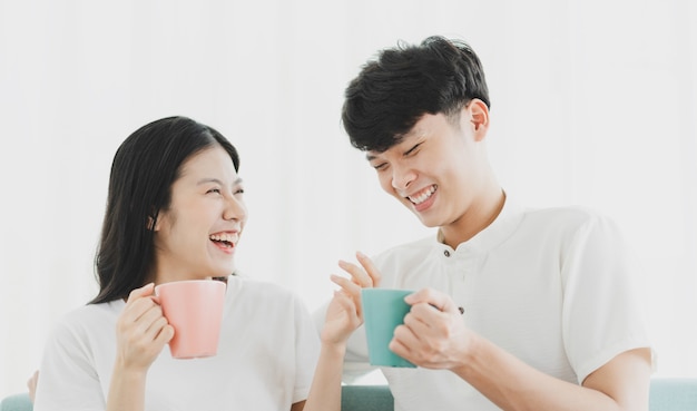 Pareja tomando café en el sofá con expresión feliz