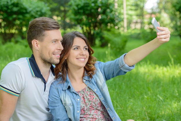 Pareja tomando fotos de ellos mismos con teléfono inteligente.