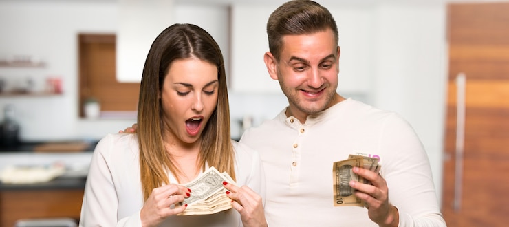 Foto pareja tomando mucho dinero en una casa