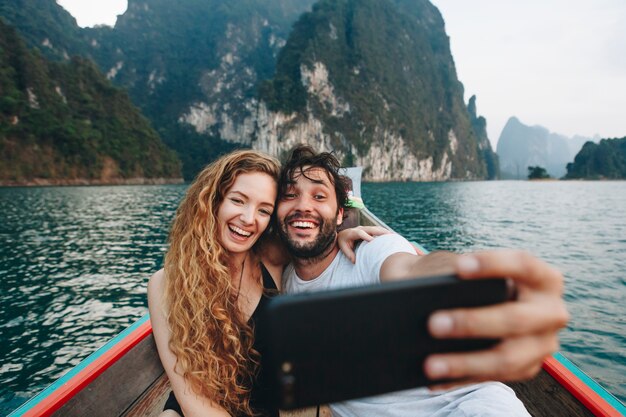 Pareja tomando selfie en un barco longtail