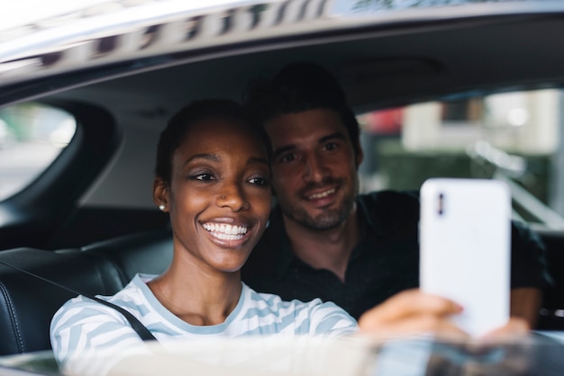 Pareja tomando selfie en un coche