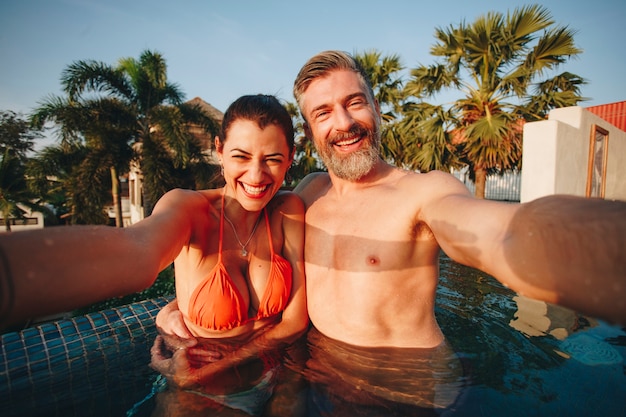 Pareja tomando una selfie en una piscina