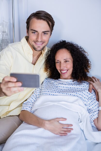 Foto pareja tomando selfie en sala