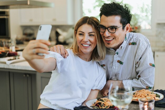 Pareja tomando un selfie durante su cena