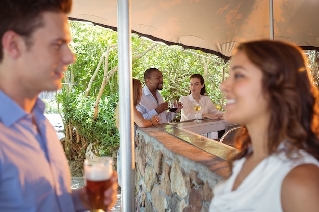 Pareja tomando un vaso de cerveza en el mostrador