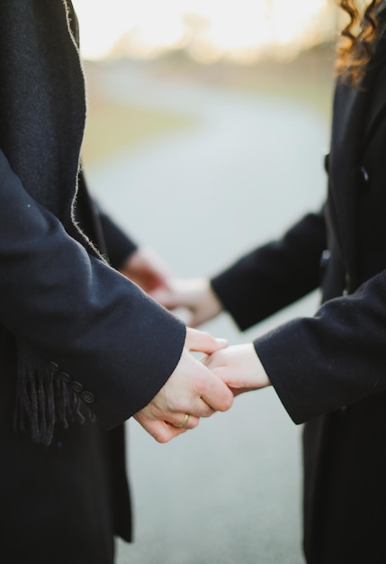 Una pareja tomándose de la mano, la palabra amor está en la mano derecha.