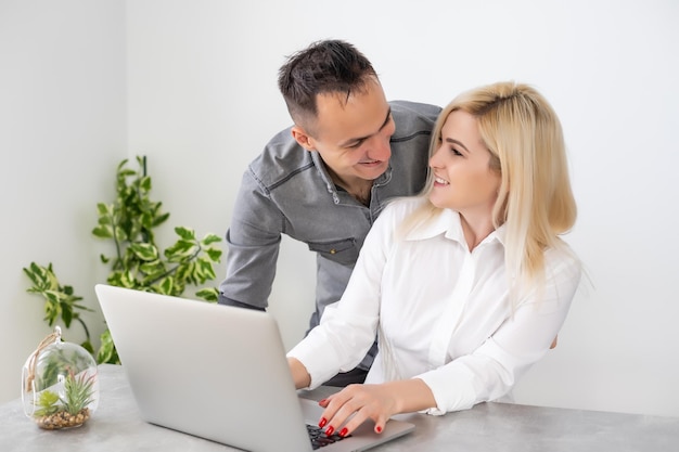 Pareja trabajando en una laptop en la oficina, una mujer y un hombre con una laptop