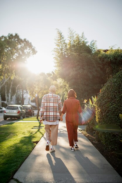 Foto pareja trans caminando mientras se toma de la mano en las calles de la ciudad