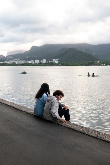 Foto pareja triste y contemplativa junto al lago