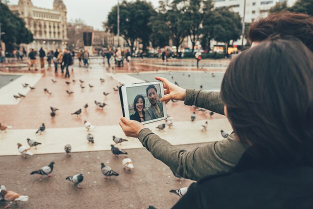 Pareja de turistas asiáticos tomando un selfie en la tableta