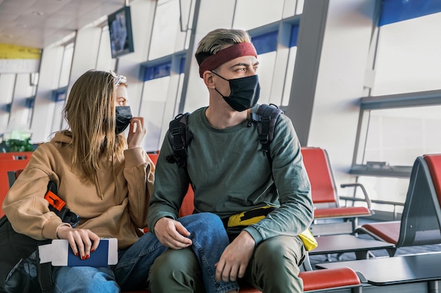 Foto una pareja de turistas esperan su vuelo en un aeropuerto vacío durante la pandemia