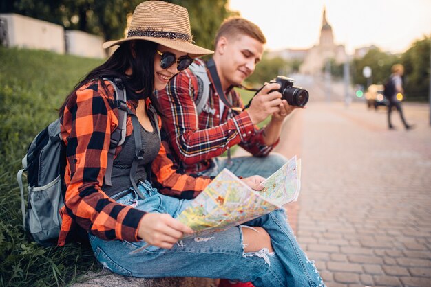 Pareja de turistas estudian el mapa de atracciones