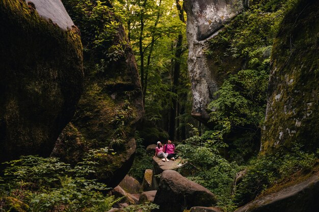 Una pareja de turistas haciendo senderismo en un cañón en el bosque.