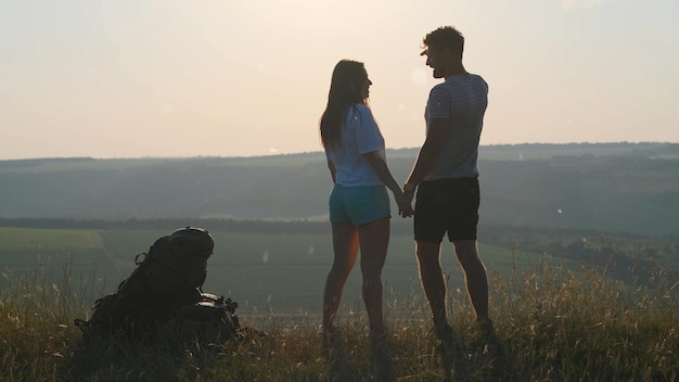 La pareja de turistas de pie en la cima de la montaña