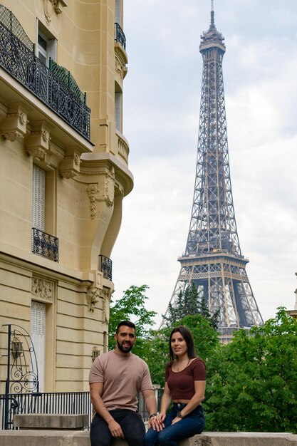 Pareja de turistas románticos en una calle parisina con la torre eiffel al fondo