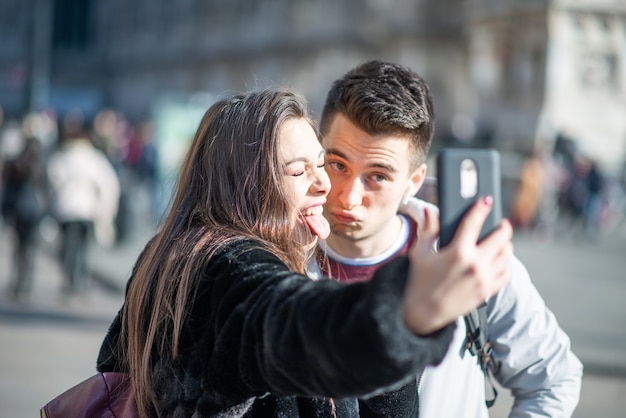 Pareja de turistas tomando un selfie en la ciudad de Milán, Italia