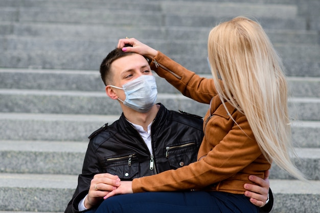 Pareja usa una máscara médica caminando en la calle de la ciudad