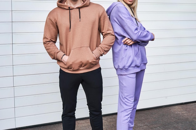 La pareja usa sudaderas de ropa de calle en blanco, suéter de hombre y mujer, maqueta de logotipo de diseño.