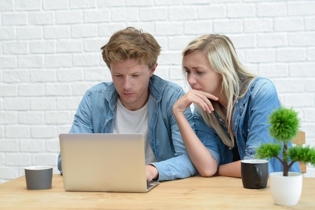 Una pareja usando una computadora portátil en casa