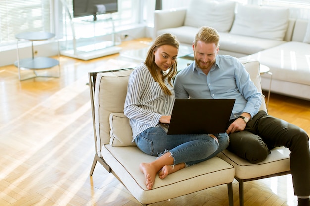 Pareja usando laptop en la habitación