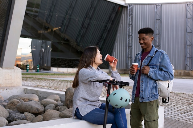 Foto pareja usando scooter eléctrico para transporte