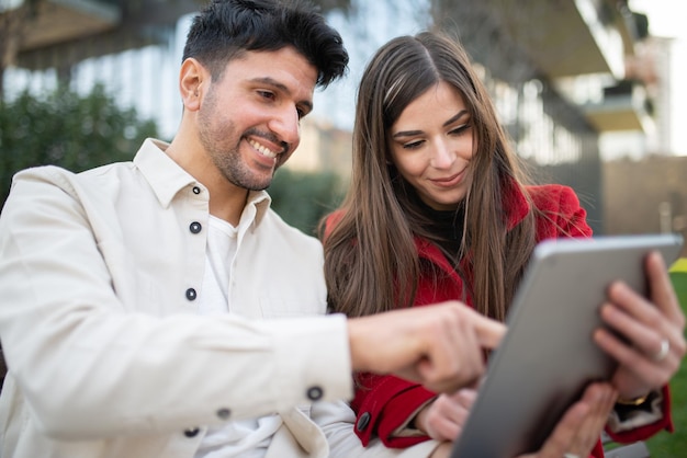 Pareja usando una tableta al aire libre