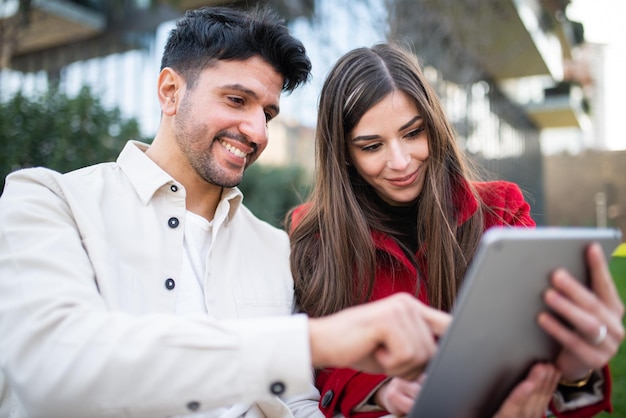 Pareja usando una tableta al aire libre