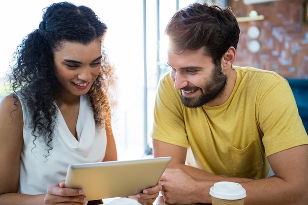 Foto pareja usando una tableta digital en cafetería