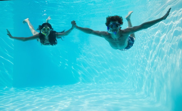 Pareja usando tubos en la piscina