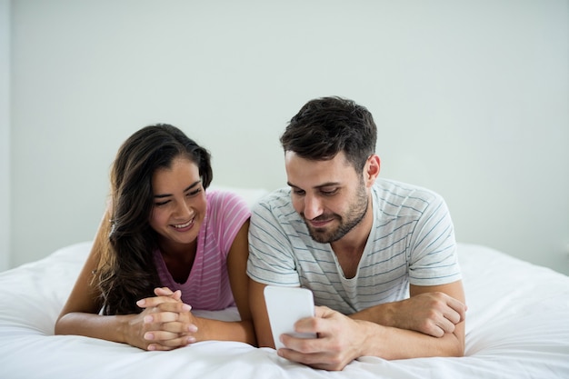 Foto pareja, utilizar, teléfono móvil, en, el, dormitorio, en casa