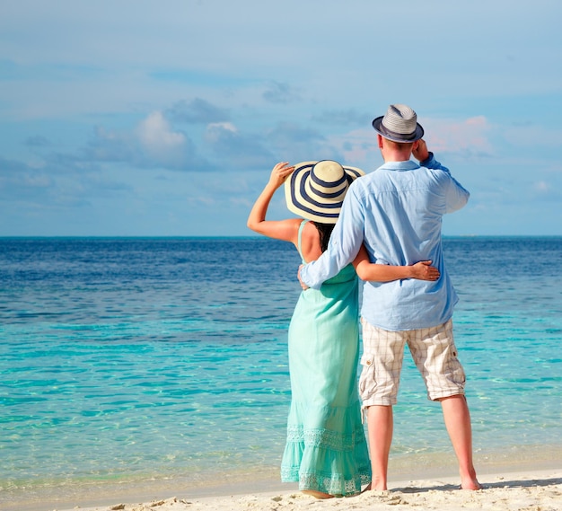 Pareja de vacaciones caminando en una playa tropical Maldivas. Paseo romántico de hombre y mujer en la playa.