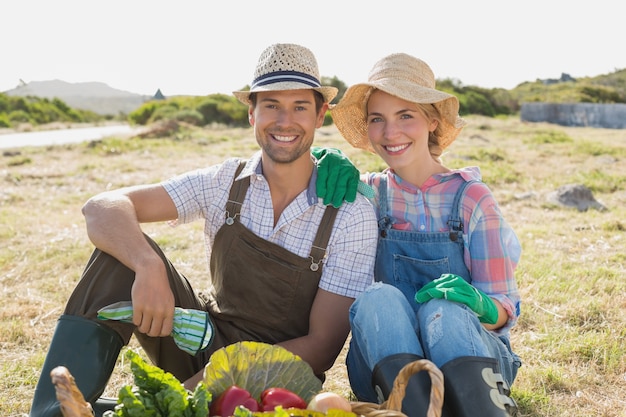 Pareja con verduras frescas en el campo