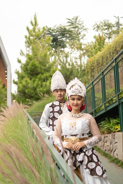 Una pareja vestida de blanco posando muy íntima e íntimamente en un parque