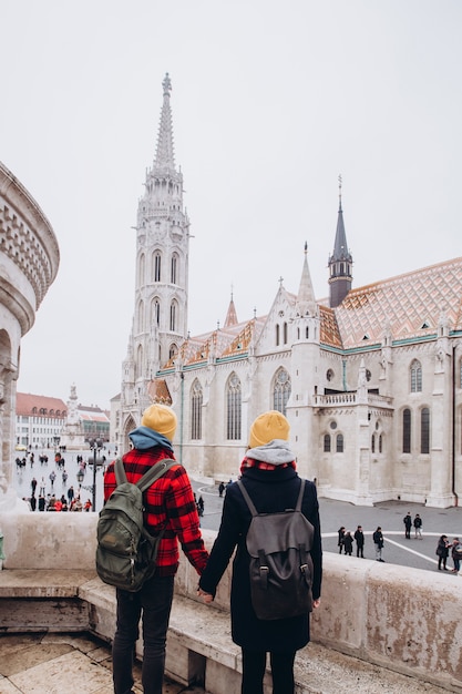 Pareja viaja por Budapest. niño y niña en gorras amarillas. Joven pareja cogidos de la mano. viaje familiar. Pareja amorosa caminando en la ciudad.